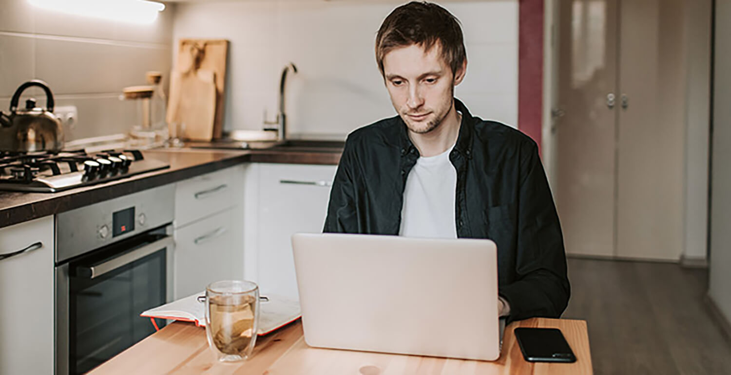 Mann arbeitet morgens früh im Home Office